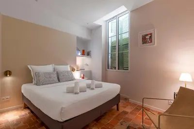 a bedroom with a large white bed with a window at NEW Appartement vieux Nice à côté de la plage AC in Nice