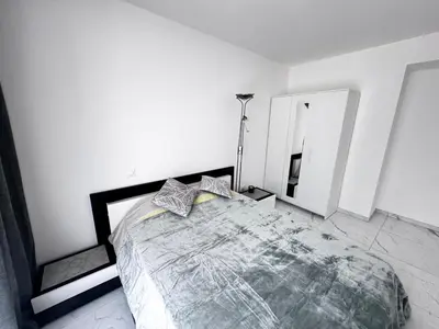 a bedroom with a large bed and a mirror at Luxueux appartement climatisé avec piscine & parking in Saint-Laurent-du-Var