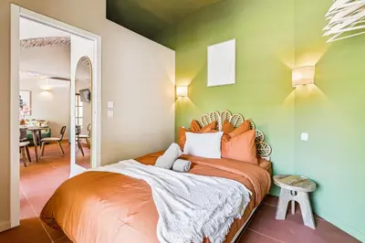 a bedroom with a bed with an orange comforter at Nice Renting - CROTTI - Authentic Immersion Sea & Beach Massena in Nice