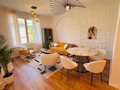 a living room with a couch and a table and chairs at Appartement 1 chambre - grande terrasse in Nice
