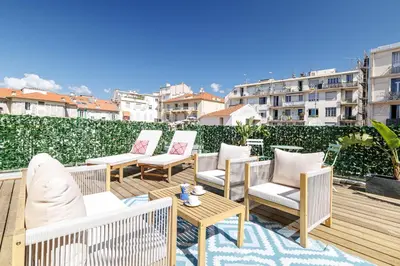 a group of chairs and tables on a balcony at Wide Open Sky Terrace 1 Bdr in Nice