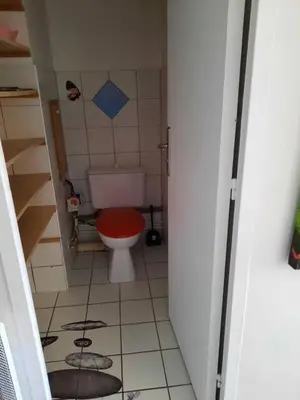 a small bathroom with a toilet with a red seat at Appartement 3 chambres spacieux prés des plages à Nice in Nice