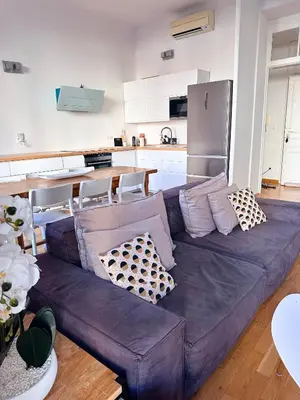 a living room with a purple couch in a kitchen at L'appart in Nice