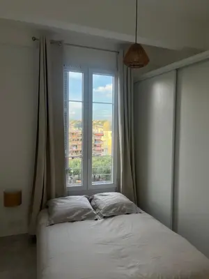 a bedroom with a bed and a large window at Havre de Paix à Nice in Nice