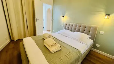 a bedroom with a large bed with two towels on it at Sublime T3 havre de paix rénové climatisé Parking in Nice