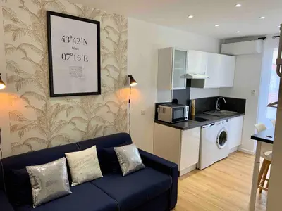 a living room with a couch and a kitchen at Magnifique studio Centre-ville in Nice