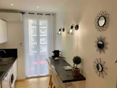 a kitchen with a counter and a table with chairs at Magnifique studio Centre-ville in Nice