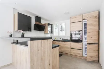 a kitchen with wooden cabinets and a counter top at Sàvega - Climatisé et Proche Plage in Nice
