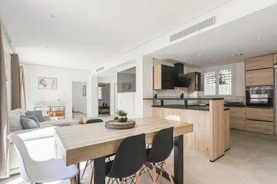 a kitchen and living room with a table and chairs at Sàvega - Climatisé et Proche Plage in Nice