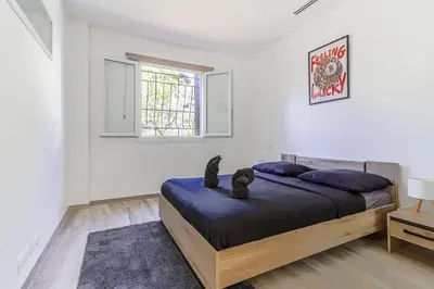 a bedroom with a bed with a cat sitting on it at Sàvega - Climatisé et Proche Plage in Nice