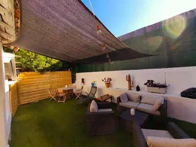 a patio with couches and a table and chairs at Magnifique 3 pièces 300 m plage jardin Parking in Cagnes-sur-Mer