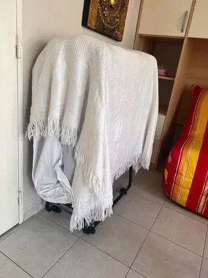 a white blanket on a chair in a room at Studio cœur de ville et au calme in Cagnes-sur-Mer