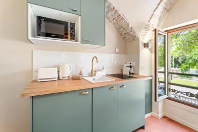 a kitchen with blue cabinets and a sink and a window at Nice Renting - CROTTIb - Studio Rare Pearl Typical Chic Massena & Sea in Nice