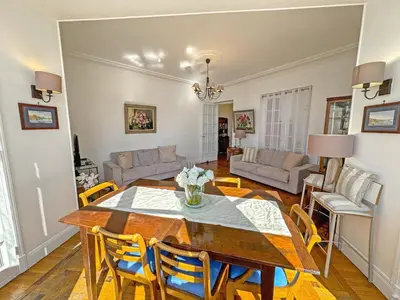 a dining room and living room with a table and chairs at Belle Epoque Azur Promenade Nice in Nice