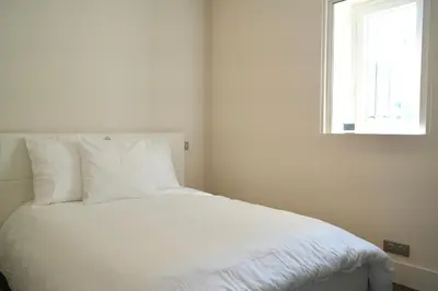a white bed in a room with a window at Villa La Mascotte in Beaulieu-sur-Mer