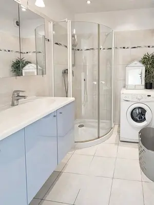 a bathroom with a sink and a washing machine at Beau 2 pieces avec vue imprenable sur la rade in Villefranche-sur-Mer