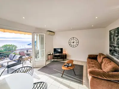a living room with a couch and a table at Beau 2 pieces avec vue imprenable sur la rade in Villefranche-sur-Mer
