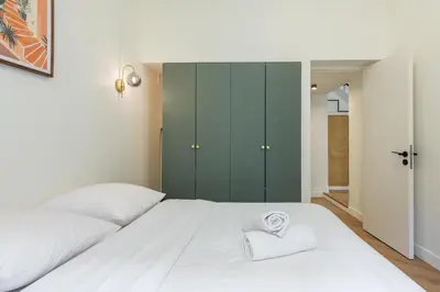 a bedroom with a white bed with a towel on it at Charme et modernite au coeur du Vieux Nice in Nice
