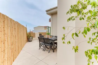 a patio with a table and a fence at COCO BEACH AP4476 by Riviera Holiday Homes in Nice