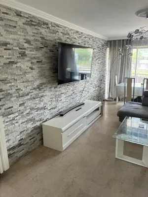 a living room with a tv on a brick wall at Nice vauban in Nice