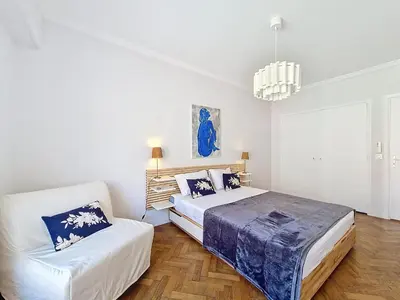 a bedroom with two beds and a chair at Nestor&Jeeves - PROMENADE DU SUD - Vue Mer in Nice