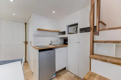 a kitchen with white walls and wooden shelves at Etudiants port - 1pers, wifi, AC in Nice