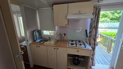 a small kitchen with a stove and a balcony at Mobil home Oasi in Cagnes-sur-Mer