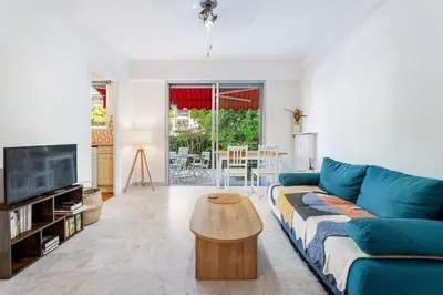 a living room with a blue couch and a table at Studio Mimosas - Welkeys in Cagnes-sur-Mer