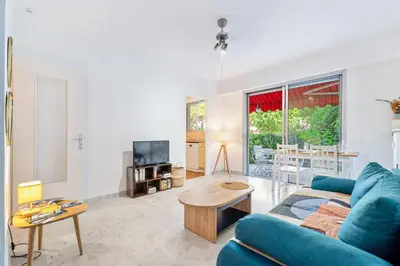 a living room with a blue couch and a table at Studio Mimosas - Welkeys in Cagnes-sur-Mer