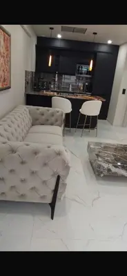 a living room with a white couch and chairs at Nice in Nice