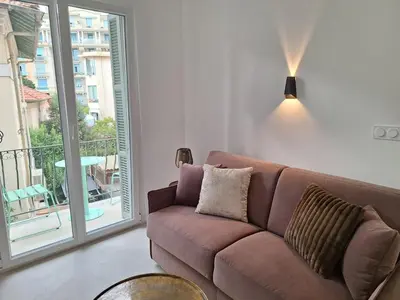 a brown couch in a living room with a balcony at Arty & Chic à Nice in Nice