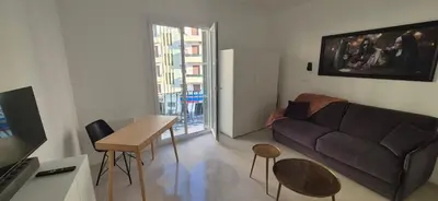 a living room with a couch and a table at Iconic and bright style in Nice in Nice