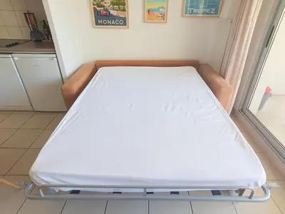 a hospital bed in a room with a kitchen at 2P pour 4 personnes grande terrasse avec lit parapluie piscine sur le toit et parking en sous-sol in Cagnes-sur-Mer