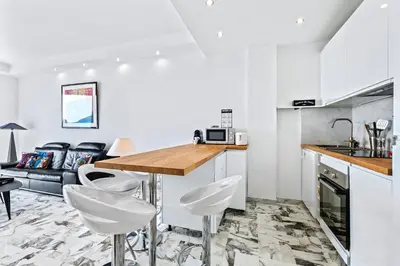 a kitchen and living room with a table and chairs at Amazing Sunset in Nice