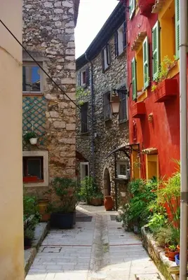 an alley in an old stone building with plants at Plaisirs entre mer et montagne in Aspremont