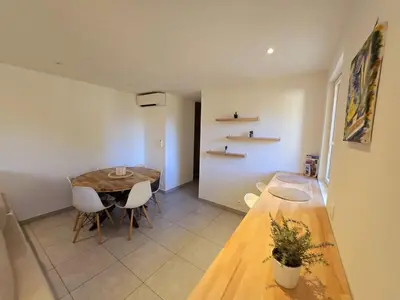 a dining room with a wooden table and chairs at Plaisirs entre mer et montagne in Aspremont
