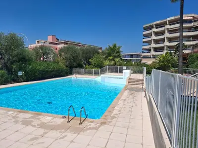 a swimming pool with blue water in front of a building at Lovely apartment with private garden and a swimming-pool in Nice