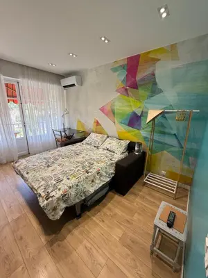 a bedroom with a bed and a colorful wall at Modern Appart Nice, proche Gare Riquier in Nice