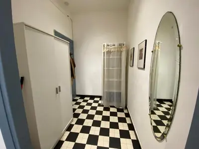a bathroom with a mirror and a checkered floor at Easy and accessible beach flat near the university in Nice