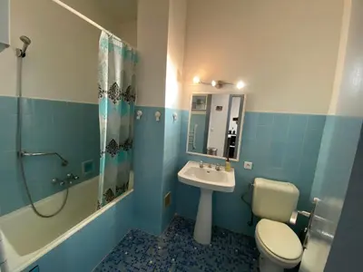 a blue bathroom with a toilet and a sink at Easy and accessible beach flat near the university in Nice
