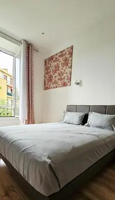 a bedroom with a large bed and a window at Spacious apartment in Cimiez in Nice