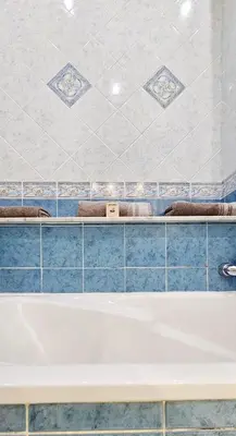 a bath tub in a bathroom with blue tiles at Spacious apartment in Cimiez in Nice
