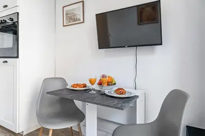 a table with two plates of food and a tv on a wall at Appartement Perle - Welkeys in Nice