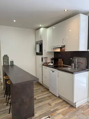 a kitchen with white cabinets and a black counter top at Charmant studio en centre de Nice in Nice
