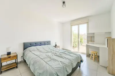 a white bedroom with a large bed and a window at Lovely 1BR with garden, private parking & Sea View in Nice