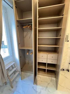 a walk in closet with white drawers and a chair at Bright, Central & Stylish 3 Min Walk to the Sea in Nice