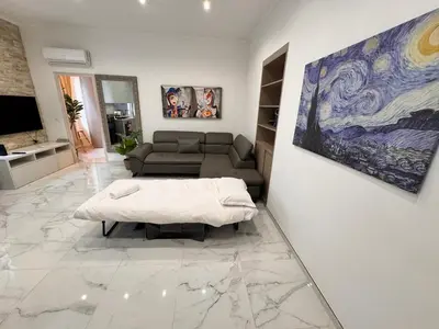 a living room with a couch and a table at Bright, Central & Stylish 3 Min Walk to the Sea in Nice
