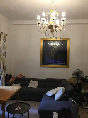a living room with a couch and a chandelier at Teranga in Nice