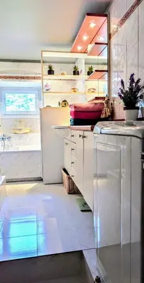 a kitchen with white cabinets and a white refrigerator at La Terrasse de Bracco in Beaulieu-sur-Mer