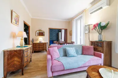 a living room with a pink couch and a table at La Terrasse de Bracco in Beaulieu-sur-Mer